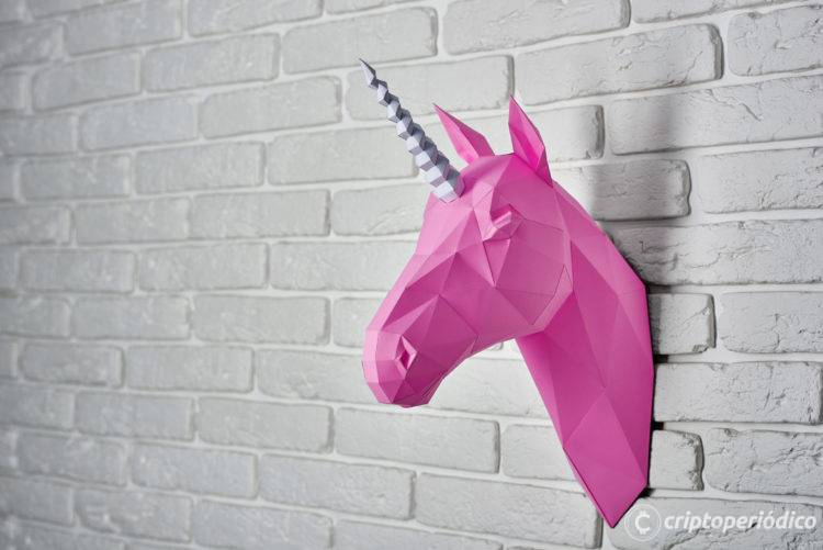 Bright pink unicorn's head hanging on the wall, made from white brick. Horse has intresting geometrical shape and straight lines. Original decoration for modern design.